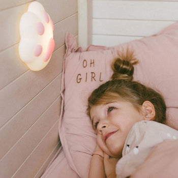 Rabbit & Friends Paw Nachtlampje verlicht aan wand, meisje kijkt ernaar in bed.