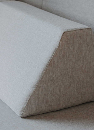 Close-up van een driehoekig rugkussen van de Monboxy Montessori speelbank in beige – laat afwerking en materiaal goed zien.