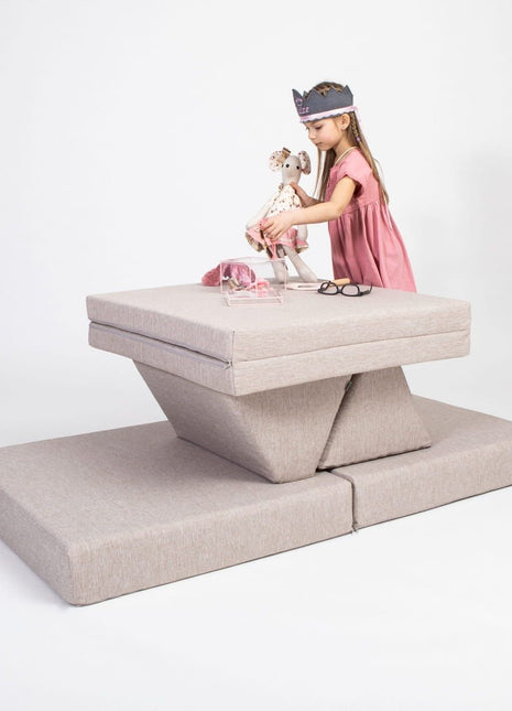 Kind speelt aan een tafelvormige opstelling van de Monboxy Montessori speelbank in beige – bevordert creativiteit en interactie.