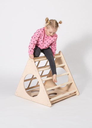 Kind zit bovenop de Berkenhouten Montessori Klimdriehoek en maakt aanstalten om af te dalen.