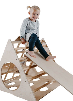 Kind zit boven op de Berkenhouten Montessori Klimdriehoek met Helling op een witte achtergrond.