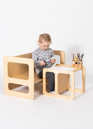Compacte Montessori Speeltafel met Stoel waarop kind papier knipt aan tafel.