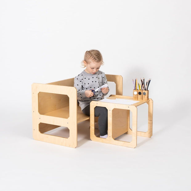 Compacte Montessori Speeltafel met Stoel waarop kind papier knipt aan tafel.