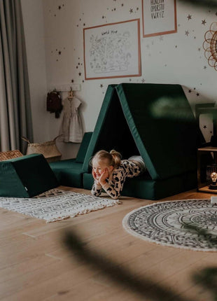 Monboxy Montessori speelbank in tentvorm met meisje liggend binnenin – een geborgen speelomgeving voor creatieve ontspanning.