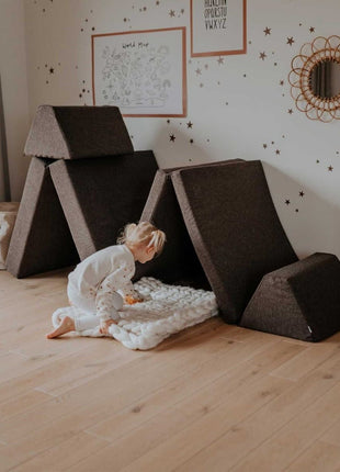 Kind knielt voor een grotachtige constructie van de Monboxy Montessori speelbank – stimuleert ontdekkend spel.