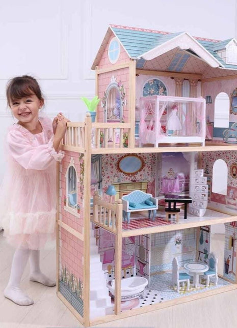 Emily houten poppenhuis van Gerardo’s Toys naast kind in roze jurk in lichte kamer.