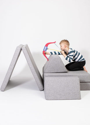 Kind speelt met een houten speelboog op een Monboxy Montessori speelbank in tentvorm – bevordert zintuiglijke ontwikkeling.