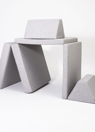 De grijze Monboxy Montessori speelbank opgebouwd in een speelhutvorm – geschikt voor fantasierijke en actieve spelvormen.