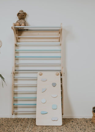 Hellingsbaan voor Pikler pastel geplaatst tegen Zweedse muur met pastel sporten in kinderkamer