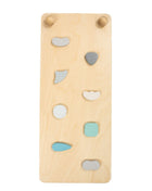 Detail van hellingsbaan voor Pikler pastel met gekleurde klimgrepen op houten plank