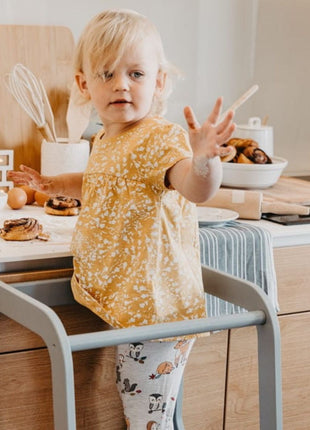 Grijze Keukenhulp Toren met kind dat met bebloemde hand aan aanrecht staat.