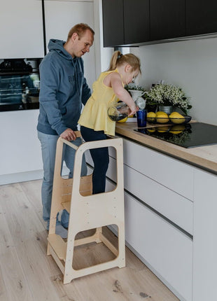 Keukenhulp Toren met kind dat water schenkt aan aanrecht, onder toezicht van volwassene.