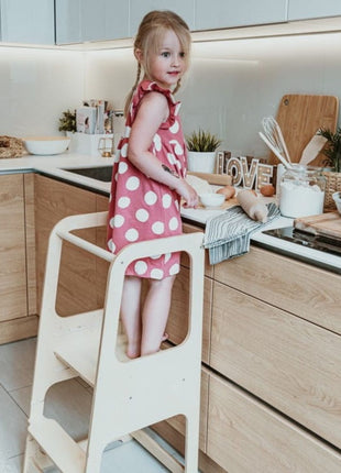 Keukenhulp Toren van naturel hout met kind dat beslag roert aan aanrecht.