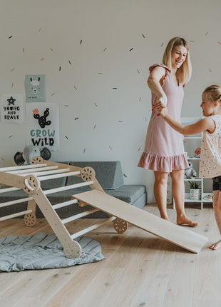 Moeder en dochter spelen samen bij de opvouwbare klimdriehoek met helling – een verbindend moment vol beweging, plezier en vertrouwen.