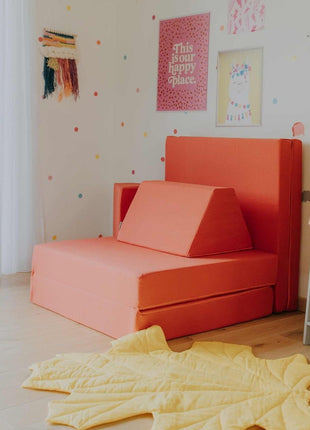 Koraalkleurige Monboxy speelbank in fauteuilvorm – ideaal voor ontspannen zitmomenten voor kinderen.