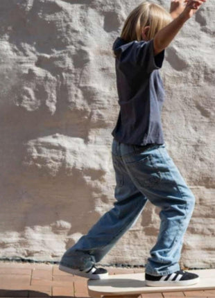 Kind balanceert op rechthoekig Leg&Go balansbord met roller op buitenterras