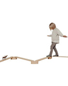 Kind balanceren op de Leg&Go evenwichtsbalkenset van 4 op witte achtergrond.