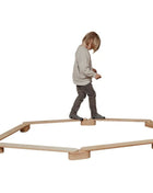 Kind balanceerd op de Leg&Go evenwichtsbalkenset van 6 in een zeshoekige opstelling.