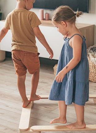 Twee kinderen balanceren op de Leg&Go evenwichtsbalkenset van 4 in een binnenruimte.
