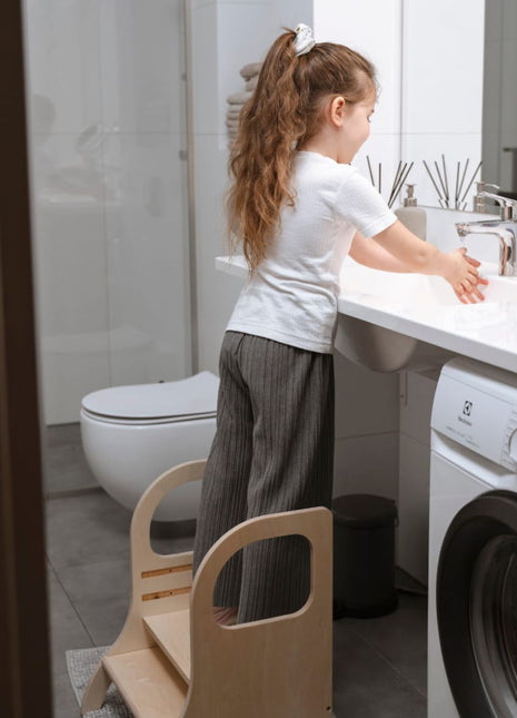 Kind staat op MIIMO in hoogte verstelbare opstap naturel om handen te wassen