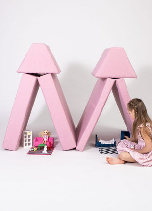 Meisje speelt met poppen naast dubbele tentconstructie gemaakt van roze Monboxy elementen.