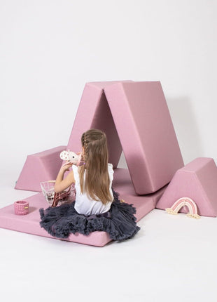 Kind speelt naast roze Monboxy tentvormige speelconstructie in neutrale studio-opstelling.