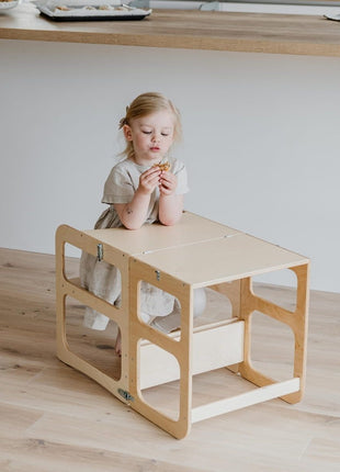 Meisje zit aan naturel Montessori 2-in-1 Keukentoren in tafelopstelling met snack.