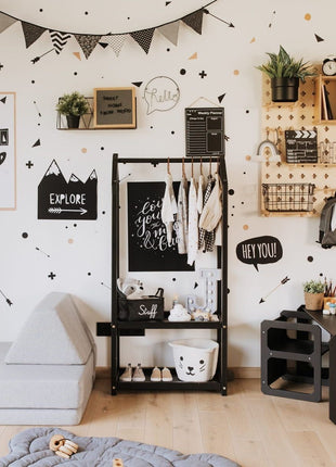 Montessori Huisvormig Kledingrek in zwarte variant met zwart-wit kinderkleding in kamer.