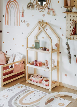 Montessori Huisvormige Plankenkast met speelgoed en servies in witte kinderkamer.