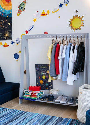 Montessori Kledingrek met 17 openingen in grijs met kinderkleding en schoenen in kinderkamer.