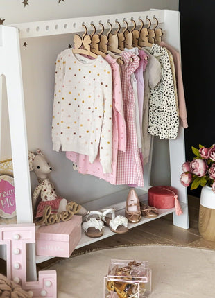 Montessori Kledingrek met 17 openingen in wit met kinderkleding en accessoires in vrolijke kamer.