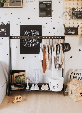 Montessori kledingrek met 17 openingen in zwarte uitvoering, ingericht in een kinderkamer met speelgoed en decoratie.