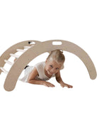 Kind speelt onder de Montessori Klimboog op een witte achtergrond.