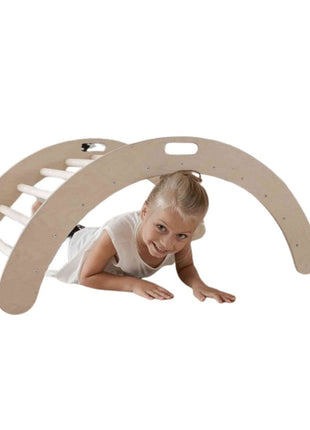 Kind speelt onder de Montessori Klimboog op een witte achtergrond.