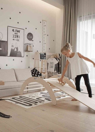 Kind speelt met een houten speeltje op de helling van de Montessori Klimboog met Helling.