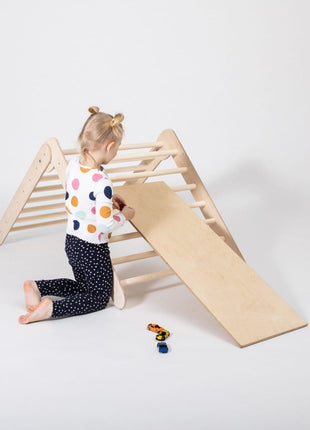 Kind speelt met speelgoedauto’s bij het Montessori Klimrek met Helling op witte achtergrond.