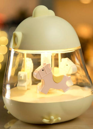 Montessori nachtlampje geel brandend met draaiende paarden, sfeerverlichting in donkere kamer.