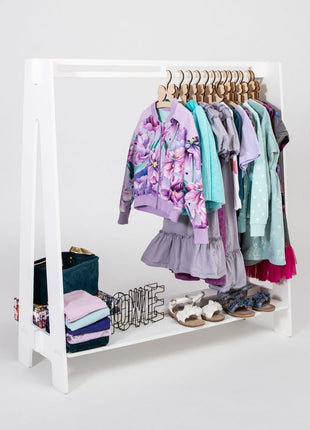 Montessori Peuterkledingrek in wit met paarse en blauwe kinderkleding op hangers.