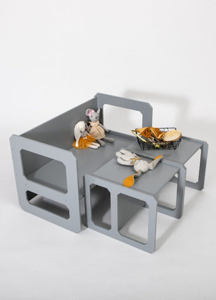 Grijze Multifunctionele Montessori Speeltafel met Twee Stoelen met poppen en mandje op tafel.