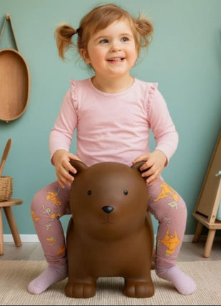 Kind zit op My First Jumpy bruin springbeer bij tipi en houten krukje.