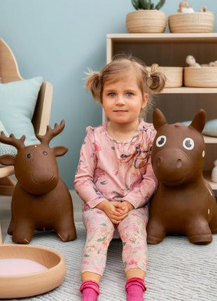 Kind zit tussen My First Jumpy bruin springpaard en bruine spring-eland.