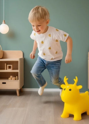 My First Jumpy geel springrendier met een springend kind ernaast in speelkamer.
