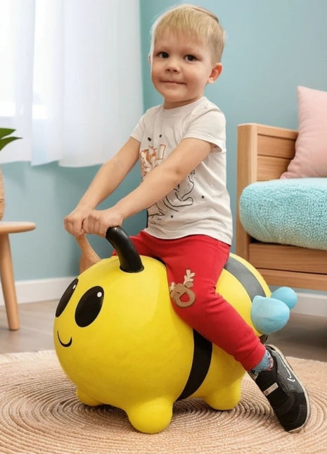 Peuter zit op gele My First Jumpy springbij met blauwe vleugels naast rotan plantenmand