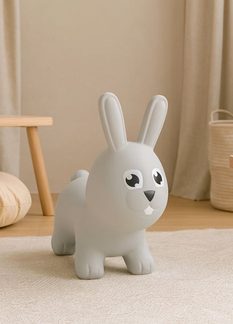 My First Jumpy grijs springkonijn in interieur bij schommel en rotan mand.