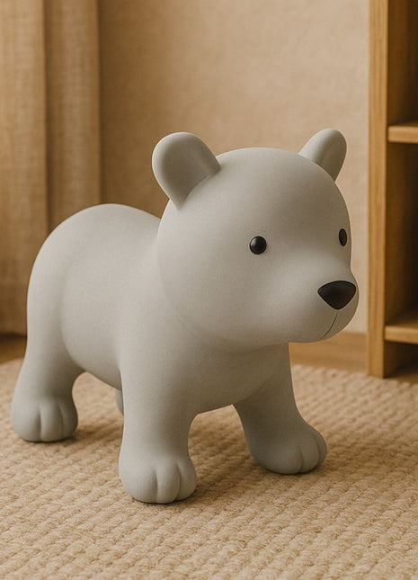 My First Jumpy grijze springbeer in interieur bij rotan mand en houten kast.