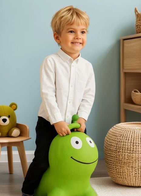 Jongen speelt op groene My First Jumpy springworm in kinderspeelkamer met rotanmand.