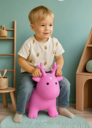 My First Jumpy roze spring-rendier met jongetje zittend op vloerkleed.