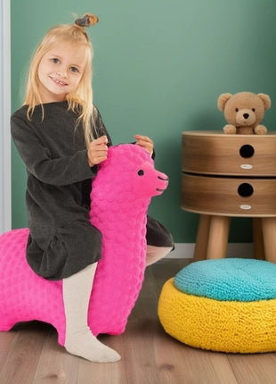 Meisje speelt met roze My First Jumpy springalpaca bij groene muur en poef.