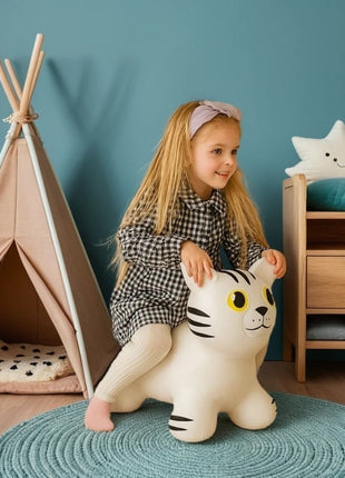 Meisje speelt op witte My First Jumpy springkat op blauw kleed naast tipi.