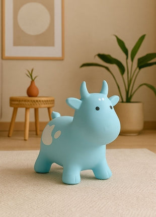 Blauwe My First Jumpy springkoe op vloerkleed met plant en wanddecoratie.